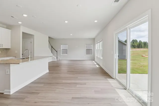 a view of a kitchen with wooden floor and a window