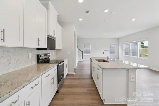 a kitchen with sink stove and cabinets