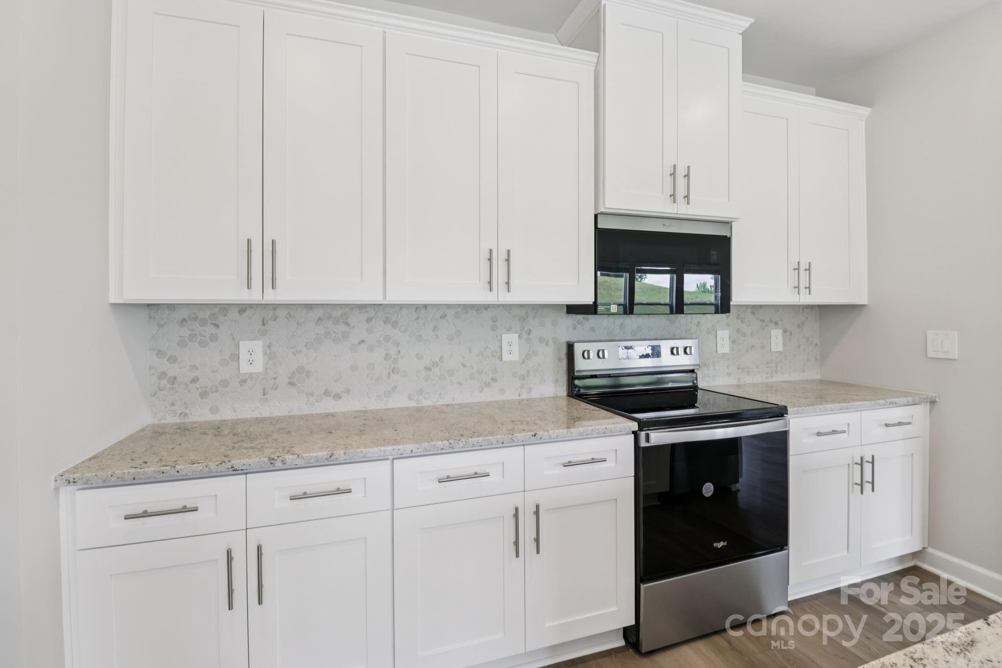 172 Murphy Mdw Road Mocksville, NC 27028 - Photo 3 of 22 a kitchen with granite countertop white cabinets and a stove