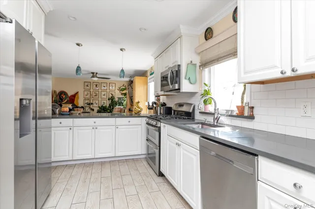 a kitchen with stainless steel appliances a sink stove and cabinets