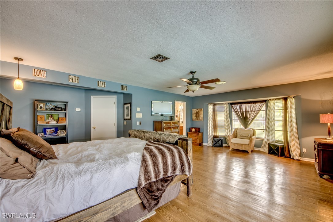 3651 Putter Point Lane Fort Myers, FL 33919 - Photo 17 of 33 a spacious bedroom with a bed and wooden floor