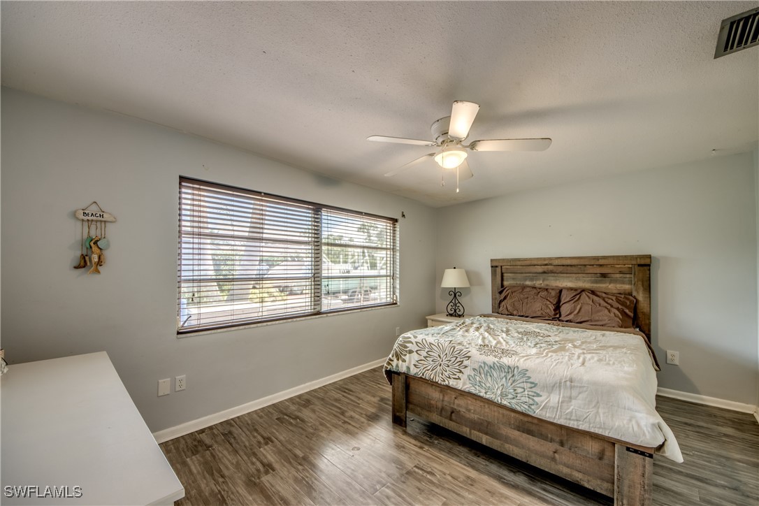 3651 Putter Point Lane Fort Myers, FL 33919 - Photo 23 of 33 a bedroom with a large bed chandelier and a window