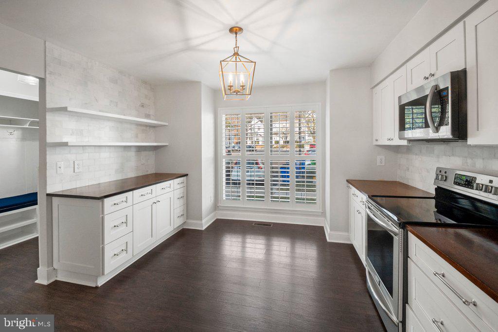 7472 Setting Sun Way Columbia, MD 21046 - Photo 7 of 40 a kitchen with stainless steel appliances granite countertop a stove a sink and a microwave