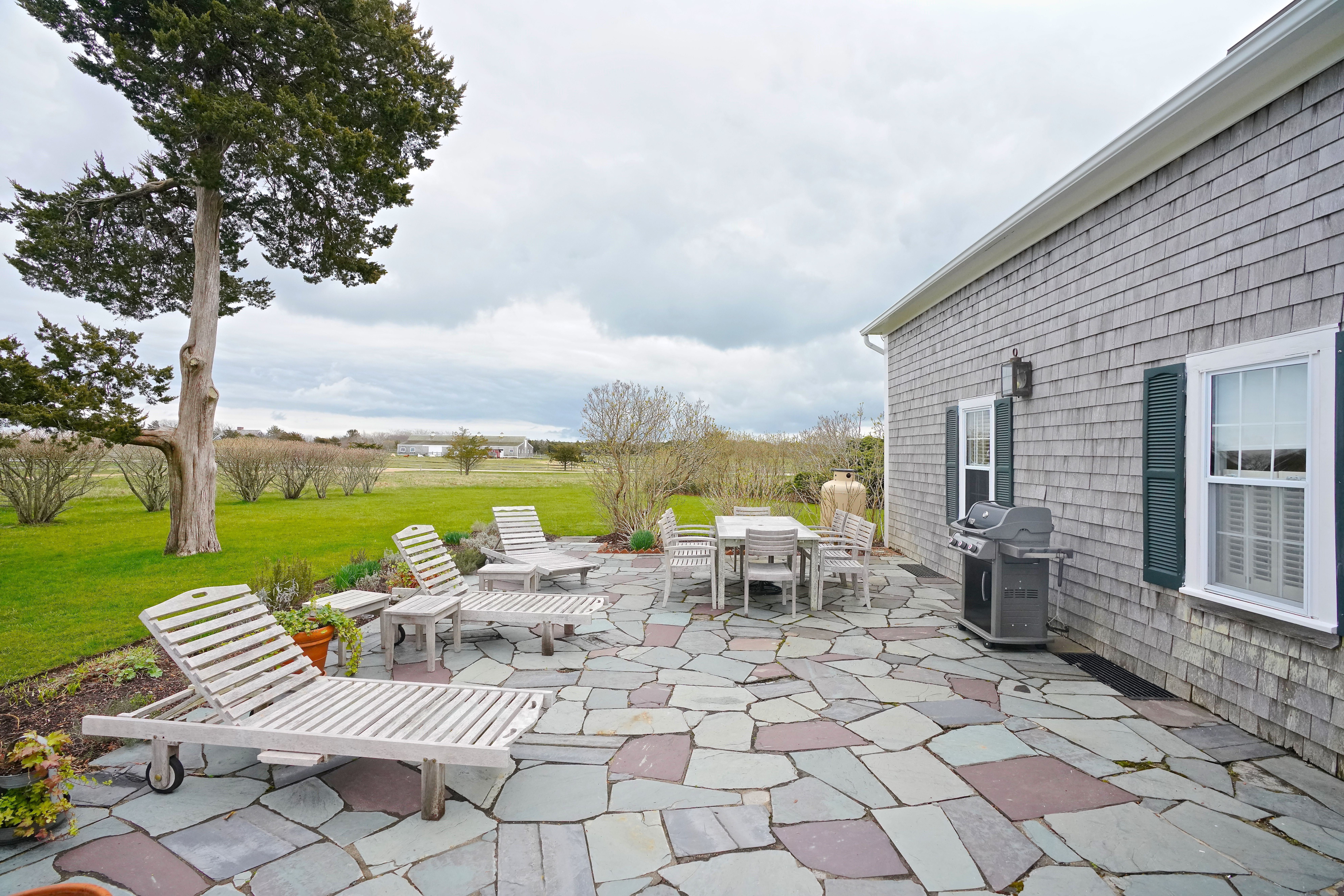 31 Butler's Cove Road Edgartown, MA 02539 - Photo 16 of 24 a view of a patio with lawn chairs floor to ceiling window and yard