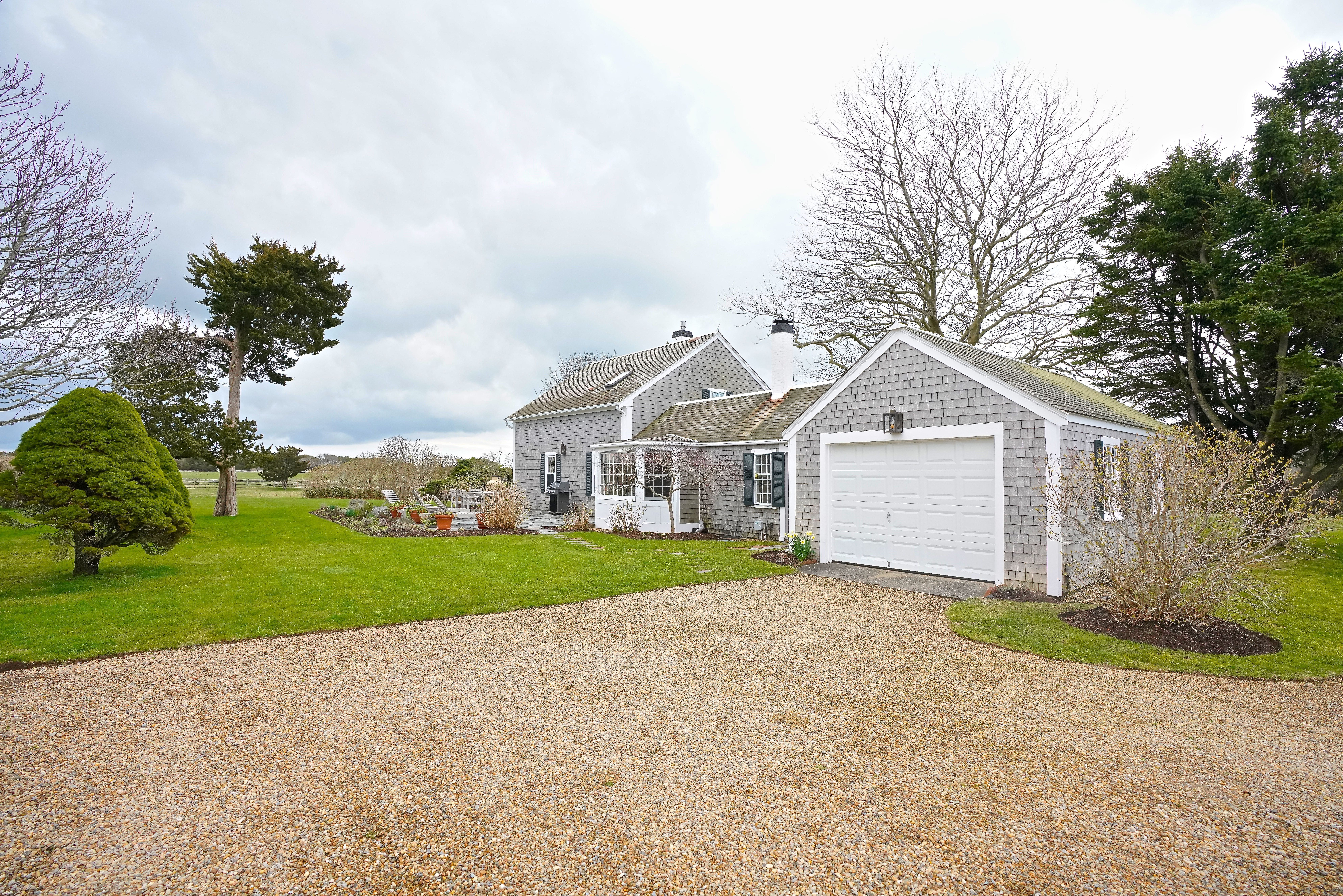 31 Butler's Cove Road Edgartown, MA 02539 - Photo 19 of 24 a front view of a house with a yard and garage