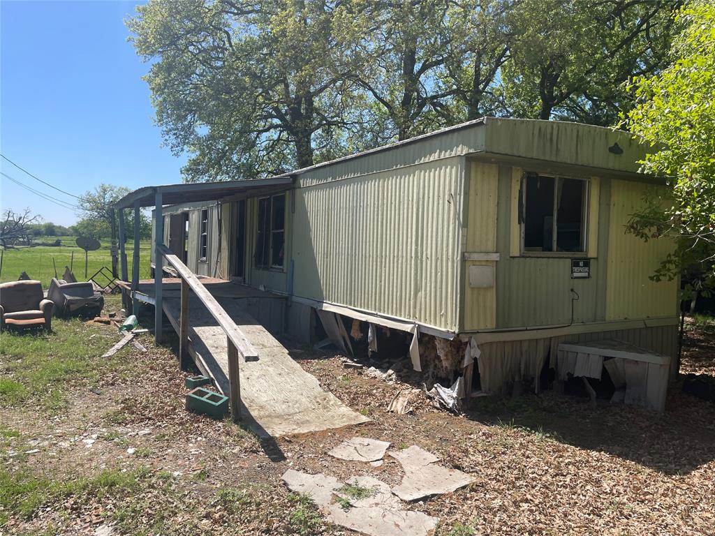 a backyard of a house with barbeque oven table and chairs