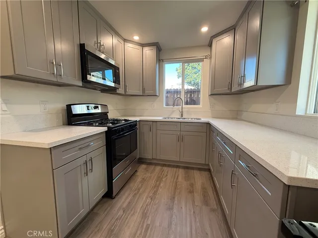 a kitchen with a sink a stove and cabinets