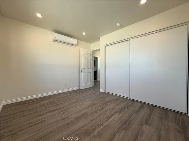 an empty room with wooden floor and a window