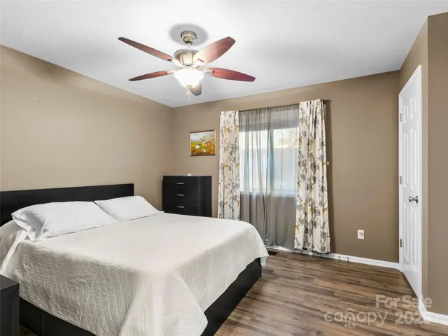 a bedroom with a large bed and a chandelier