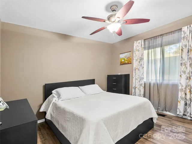 a bedroom with a large bed and a chandelier