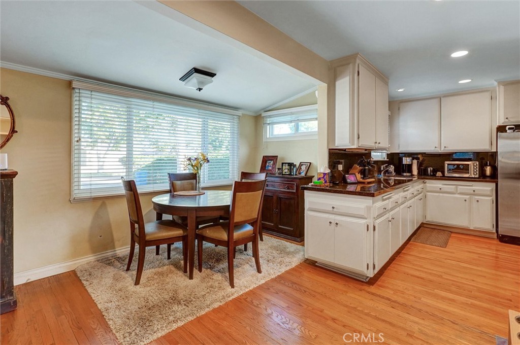 6649 Ranchito Avenue Van Nuys, CA 91405 - Photo 19 of 31 a kitchen with a dining table chairs and white appliances