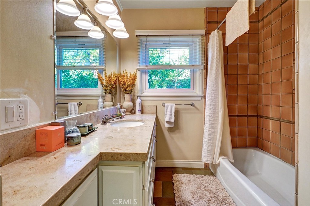 6649 Ranchito Avenue Van Nuys, CA 91405 - Photo 20 of 31 a bathroom with a granite countertop sink a large mirror and a bathtub