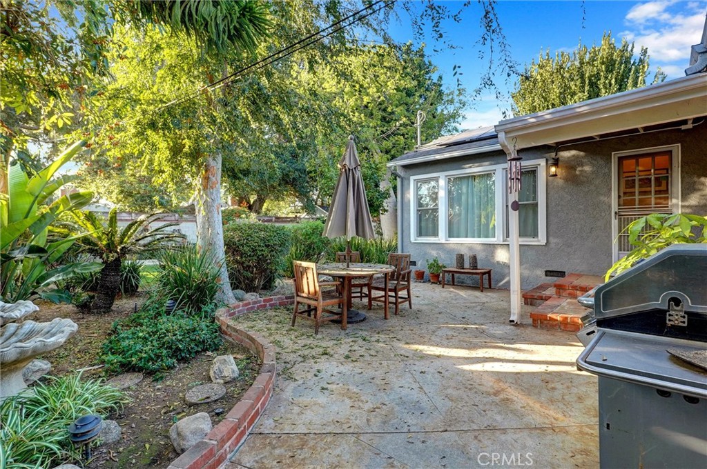 6649 Ranchito Avenue Van Nuys, CA 91405 - Photo 24 of 31 a view of a patio with table and chairs potted plants and large tree