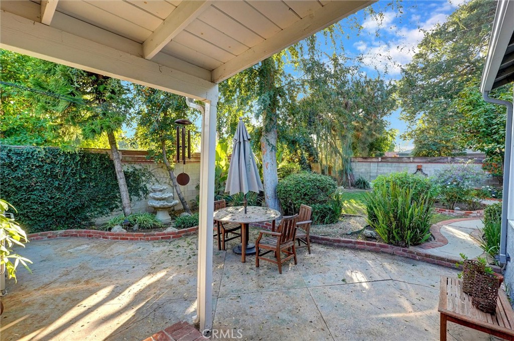 6649 Ranchito Avenue Van Nuys, CA 91405 - Photo 28 of 31 a view of a patio with table and chairs potted plants and large tree