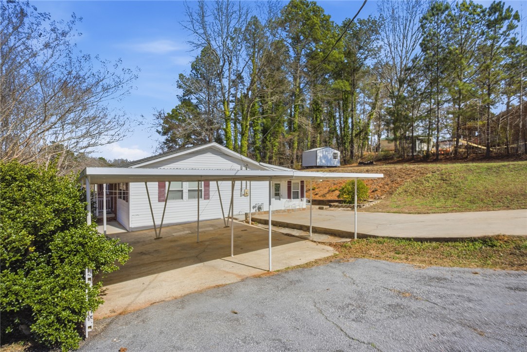 108 Hodge Street Abbeville, SC 29620 - Photo 5 of 39 A practical carport extends a warm welcome to this single-story home, nestled among natural landscaping.