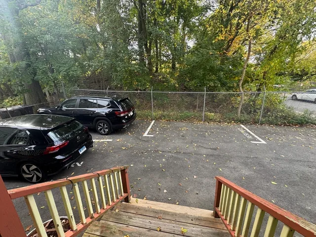 a view of a street with a car parked beside it
