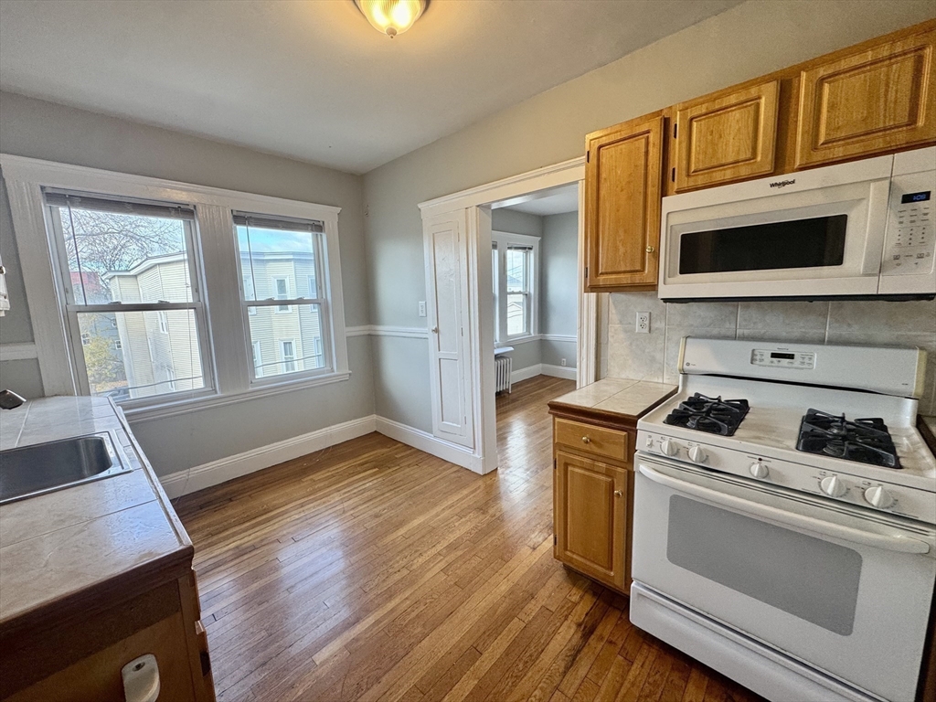 55 Brookley Road, Unit 3R Boston, MA 02130 - Photo 8 of 17 a kitchen with a stove oven and cabinets