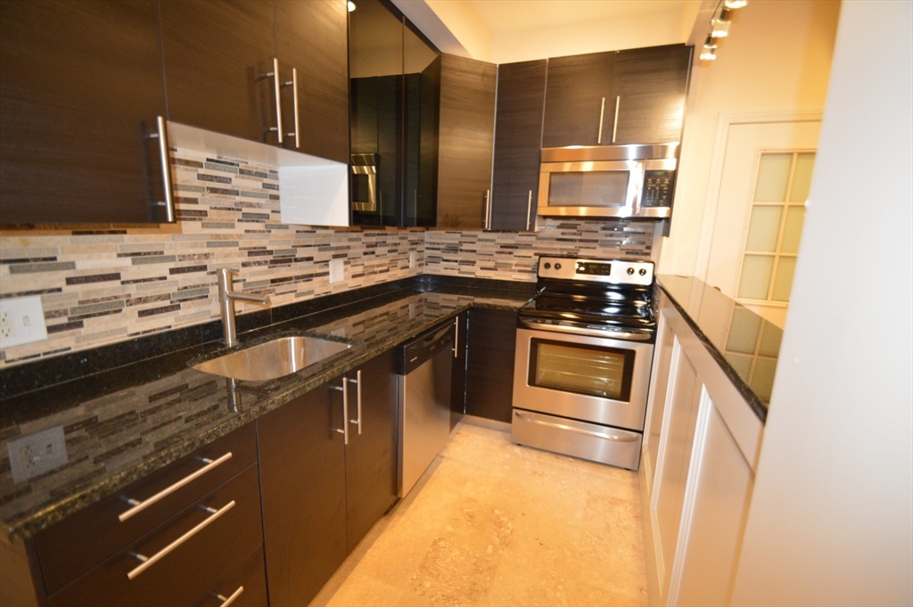 1801 Beacon Street, Unit 4 Brookline, MA 02445 - Photo 6 of 9 a kitchen with stainless steel appliances granite countertop a sink and stove