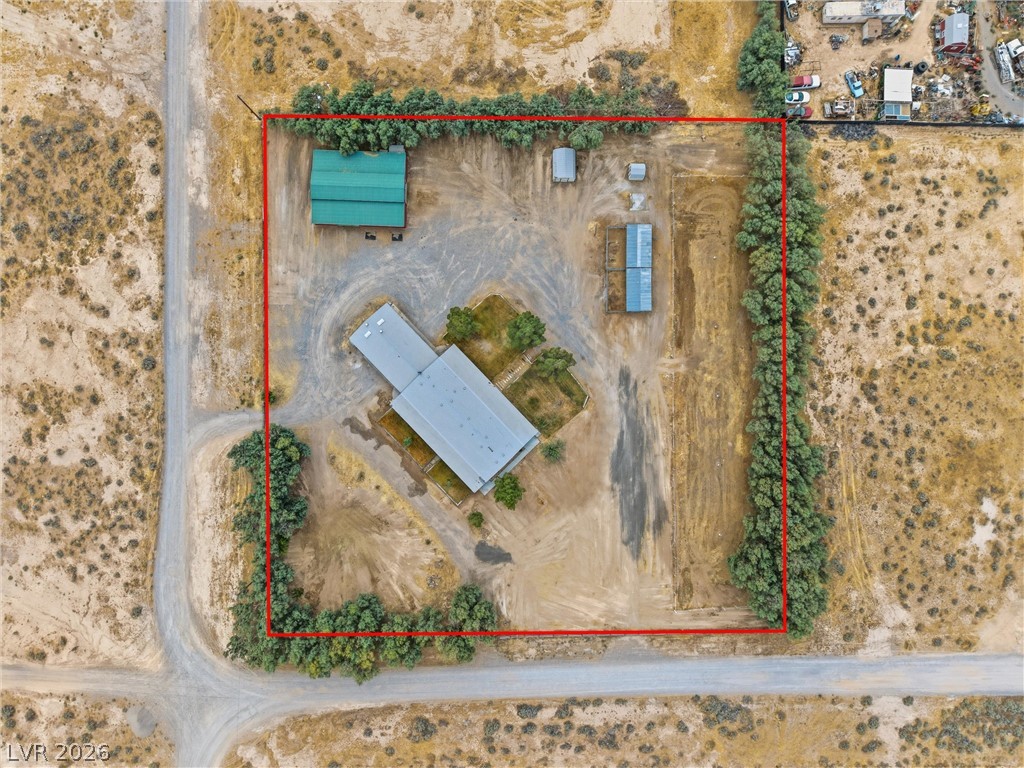 1531 West Harris Farm Road Pahrump, NV 89060 - Photo 4 of 37 An aerial view showcases a spacious property with a main structure, several outbuildings, and natural desert landscaping.