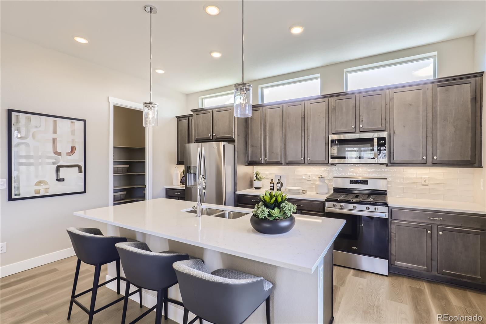 Undisclosed Address Denver, CO 80238 - Photo 11 of 21 a kitchen with a sink a kitchen island and chairs