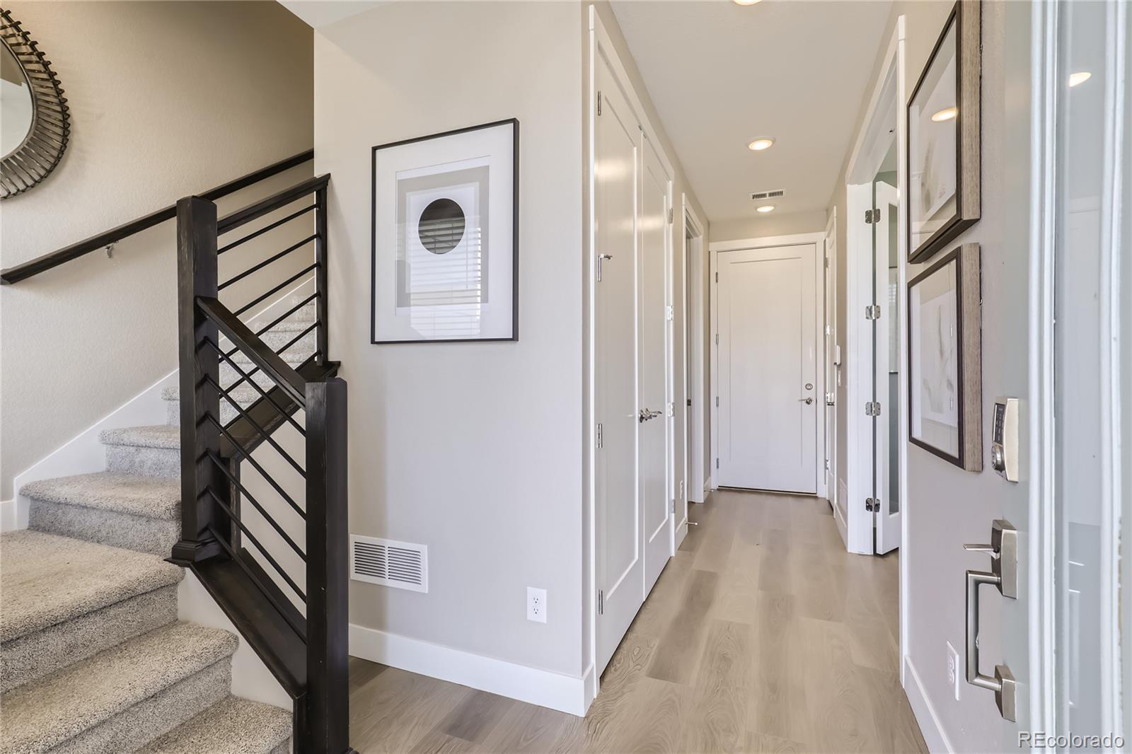 Undisclosed Address Denver, CO 80238 - Photo 3 of 21 a view of a hallway with wooden floor and staircase
