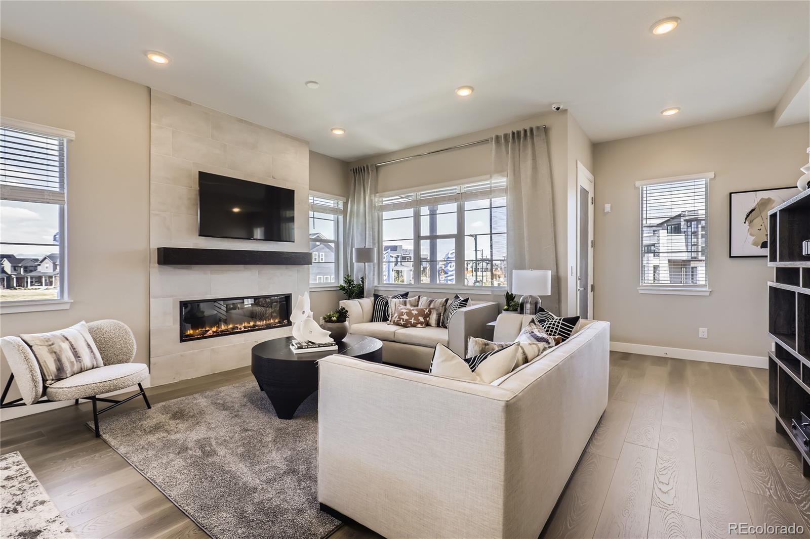 Undisclosed Address Denver, CO 80238 - Photo 6 of 21 a living room with furniture a fireplace a flat screen tv and wooden floor