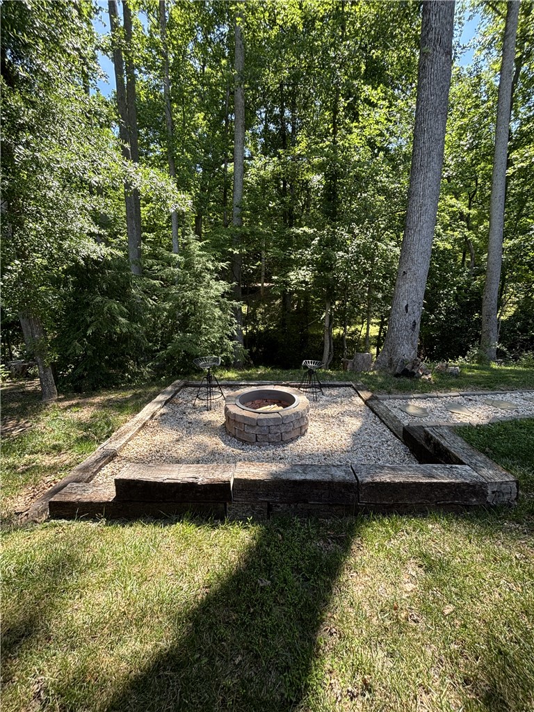 430 Johnson Road Central, SC 29630 - Photo 32 of 36 An inviting outdoor fire pit area, perfect for enjoying cool evenings under a canopy of mature trees.