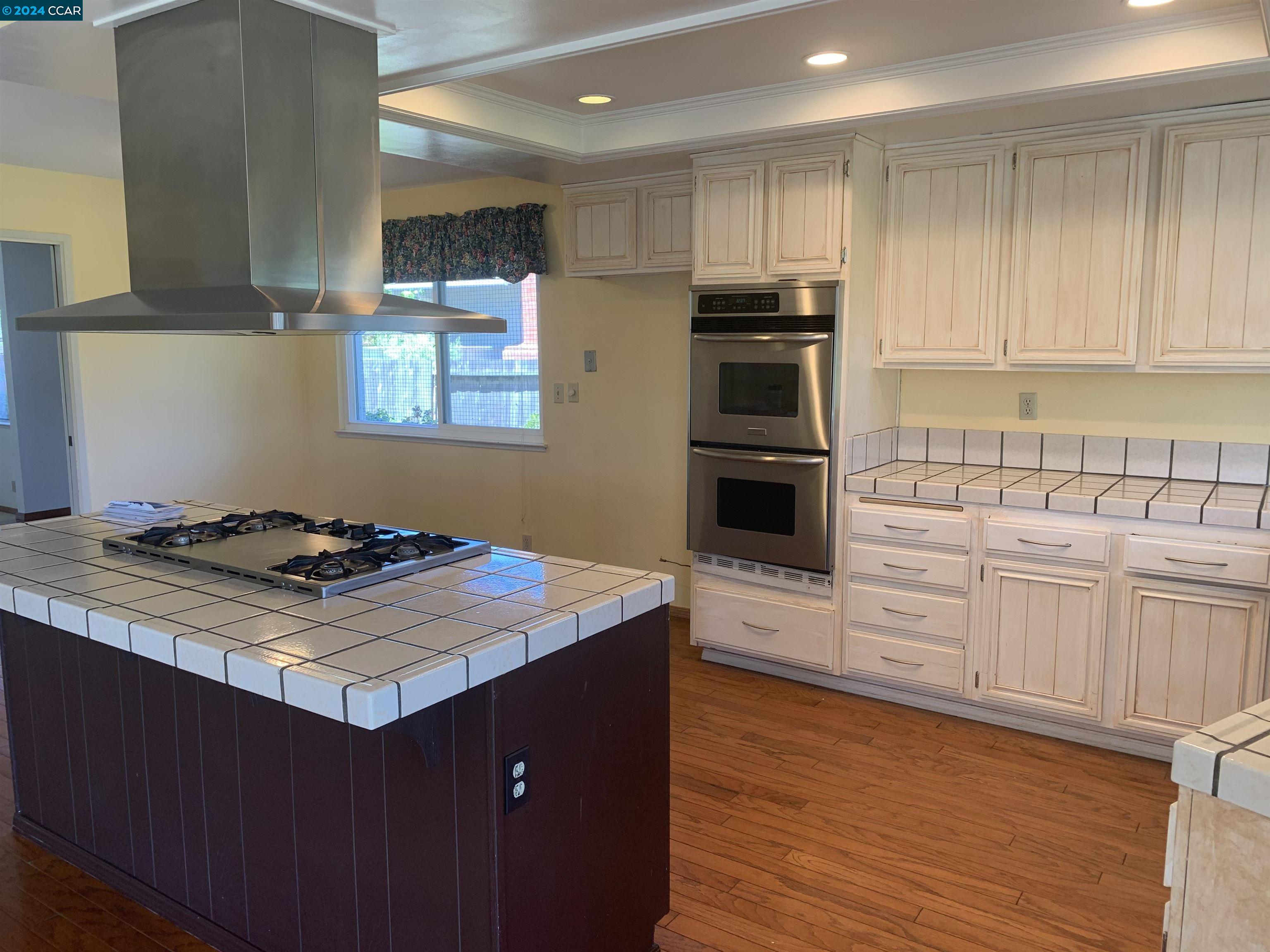 9462 Thunderbird Place San Ramon, CA 94583 - Photo 15 of 17 a kitchen with kitchen island granite countertop a sink cabinets and stainless steel appliances