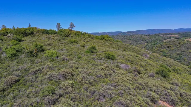 an aerial view of a houses with a lush green hillside