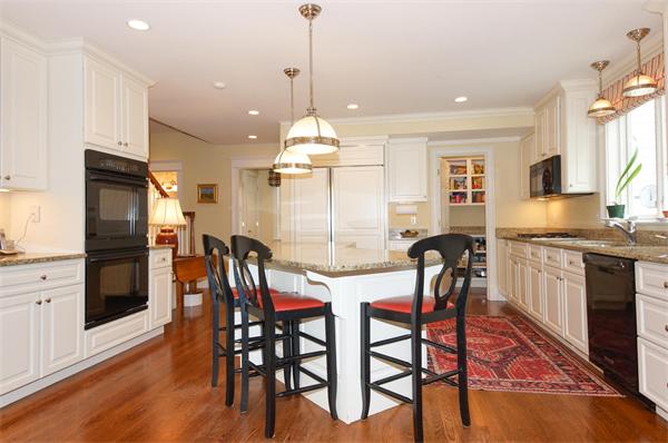 46 Coburn Hill Road Concord, MA 01742 - Photo 6 of 27 a kitchen with stainless steel appliances granite countertop a stove a refrigerator a kitchen island a dining table and chairs with wooden floor