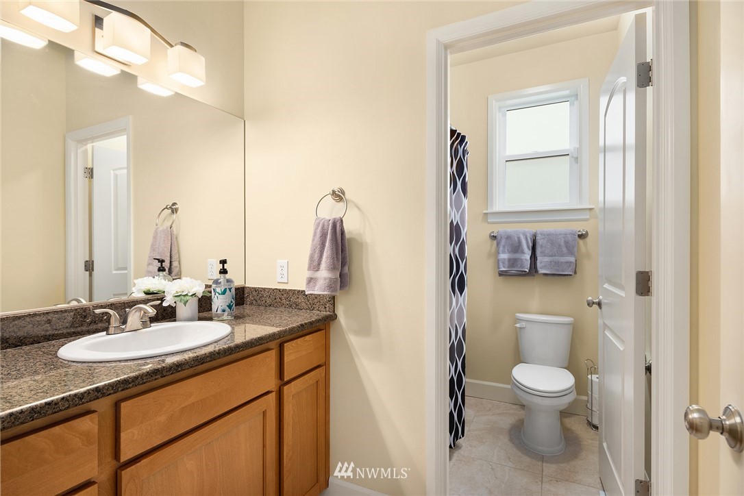 6753 Southeast 2nd Street Renton, WA 98059 - Photo 11 of 32 a bathroom with a granite countertop toilet sink and mirror