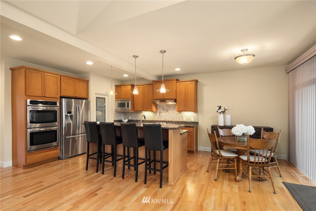 6753 Southeast 2nd Street Renton, WA 98059 - Photo 6 of 32 a kitchen with a dining table chairs and refrigerator