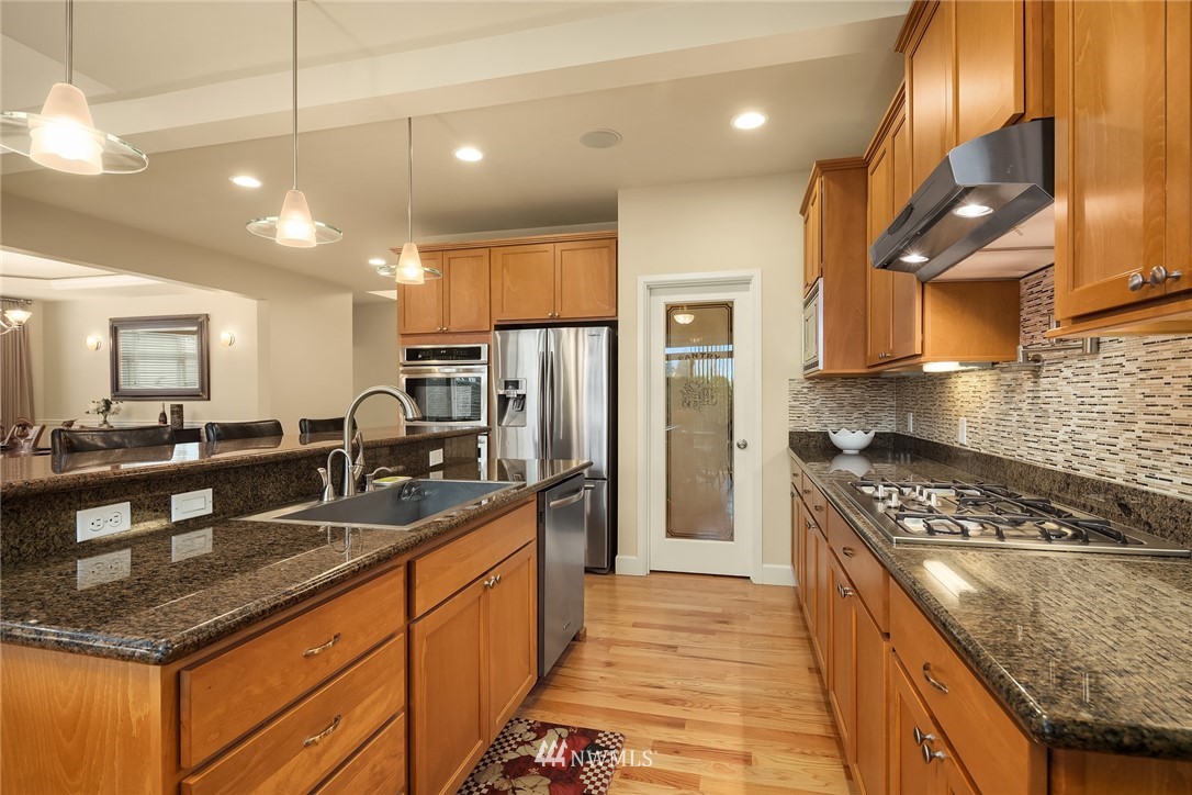 6753 Southeast 2nd Street Renton, WA 98059 - Photo 7 of 32 a kitchen with stainless steel appliances granite countertop a sink a stove and a refrigerator