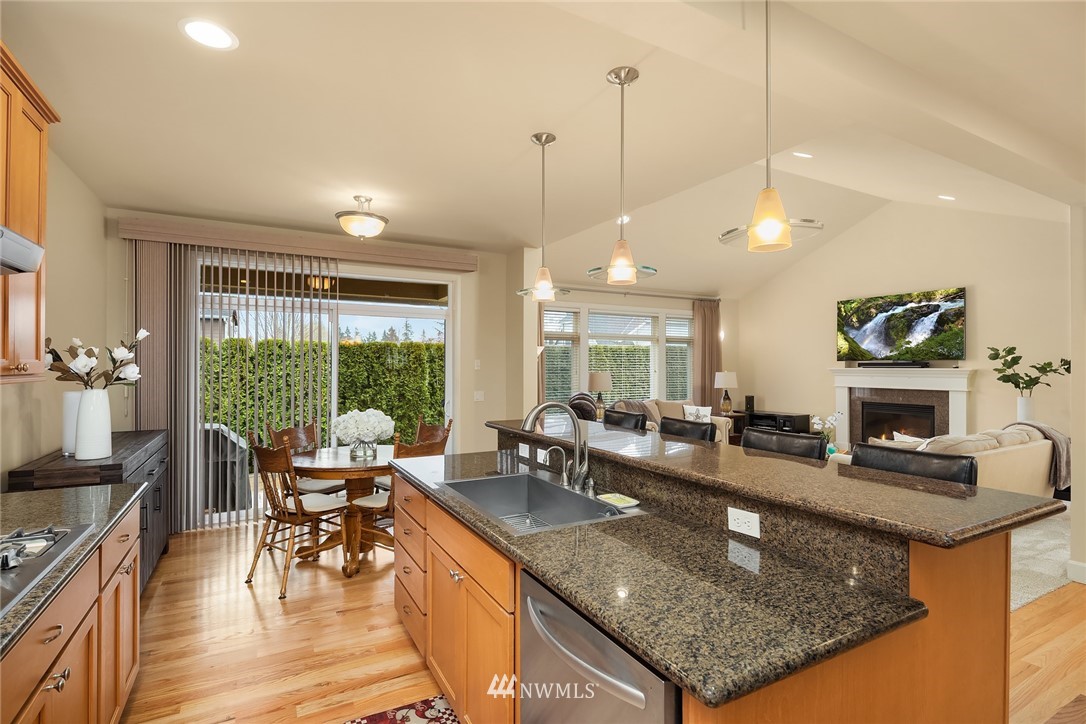 6753 Southeast 2nd Street Renton, WA 98059 - Photo 8 of 32 a kitchen with granite countertop a stove a sink a dining table and chairs