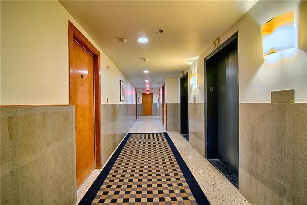 710 Colorado Street, Unit G9 Austin, TX 78701 - Photo 21 of 25 A well-lit corridor with sleek elevators awaits, offering easy access to residences.