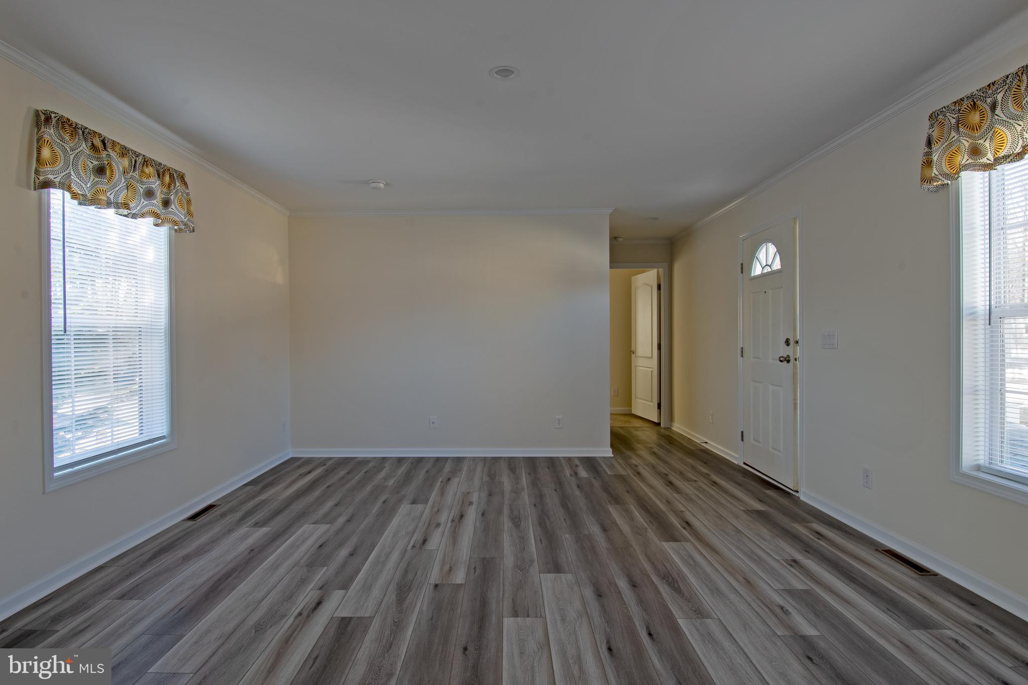 86 Longbow Lane, Unit 86 Hartly, DE 19953 - Photo 11 of 17 a view of an empty room with wooden floor and a window