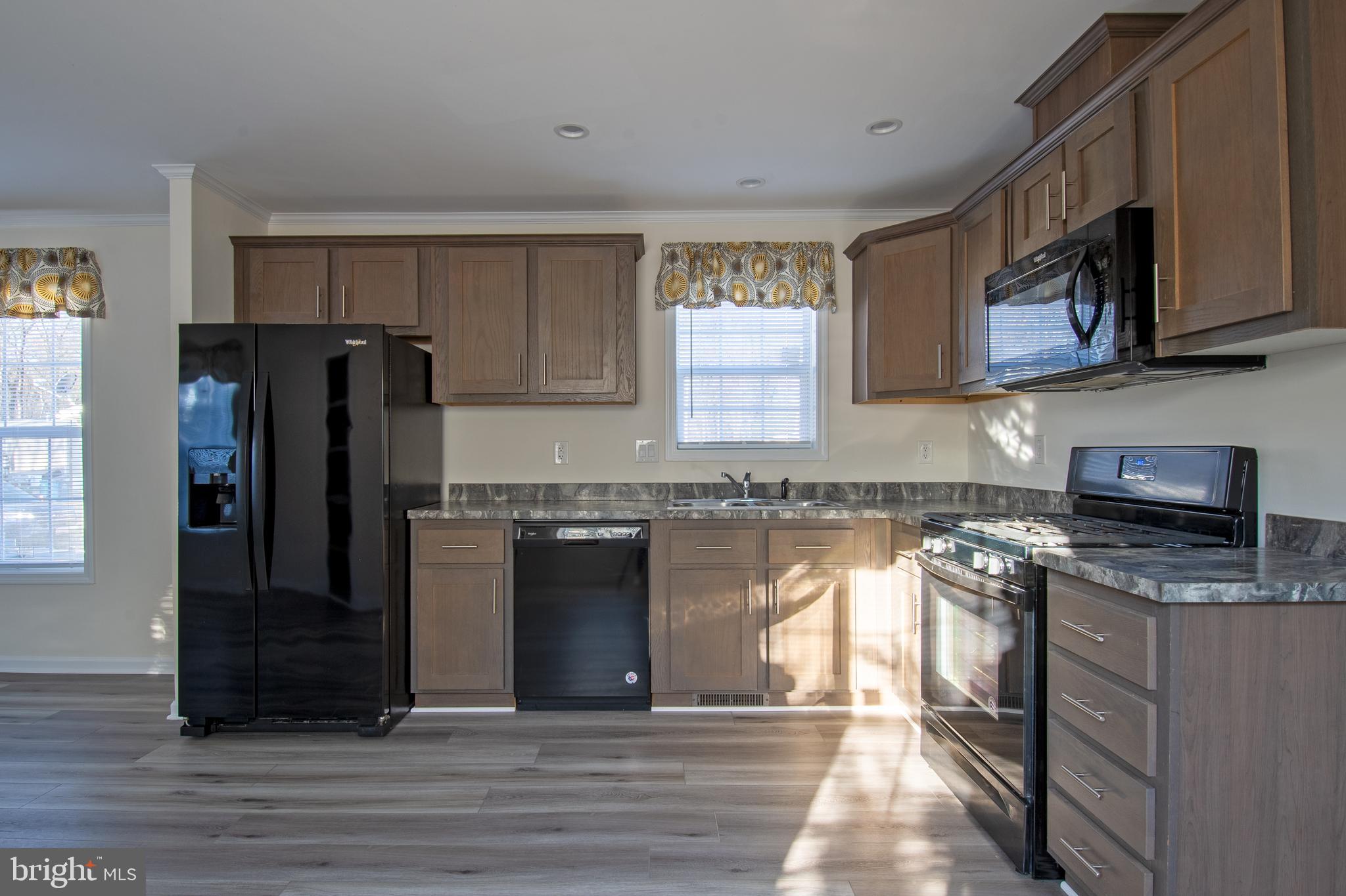 86 Longbow Lane, Unit 86 Hartly, DE 19953 - Photo 12 of 17 a kitchen with stainless steel appliances granite countertop a refrigerator and a stove top oven