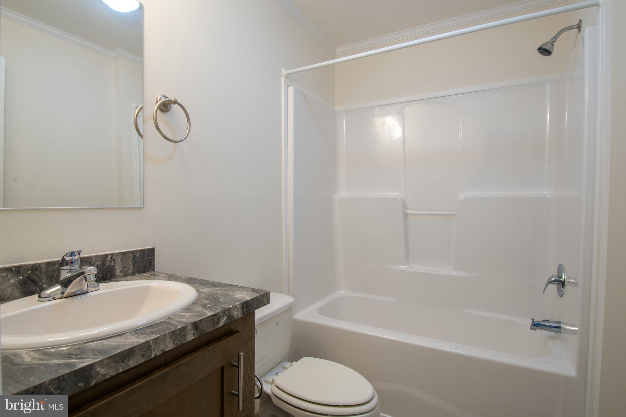 86 Longbow Lane, Unit 86 Hartly, DE 19953 - Photo 7 of 17 a bathroom with a granite countertop sink toilet and shower