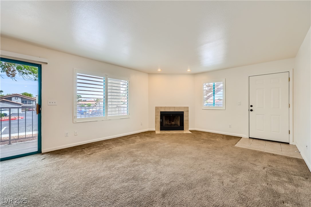 1575 West Warm Springs Road, Unit 1613 Henderson, NV 89014 - Photo 7 of 39 Unfurnished living room with baseboards, recessed lighting, carpet, and a tile fireplace