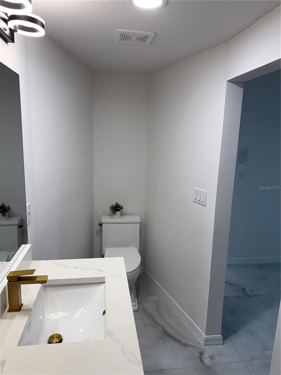 5025 Highway 54 New Port Richey, FL 34652 - Photo 23 of 39 a bathroom with a sink a toilet and a window