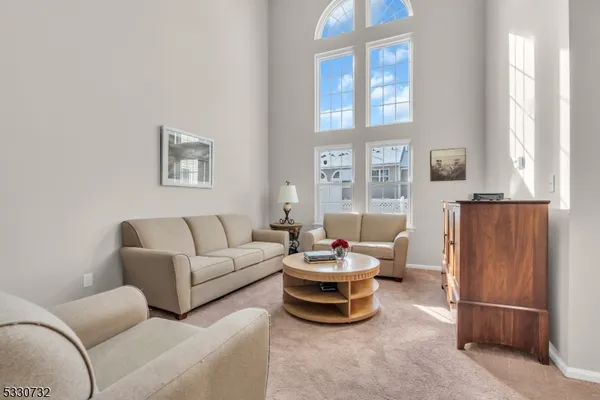 a living room with furniture a window and a refrigerator