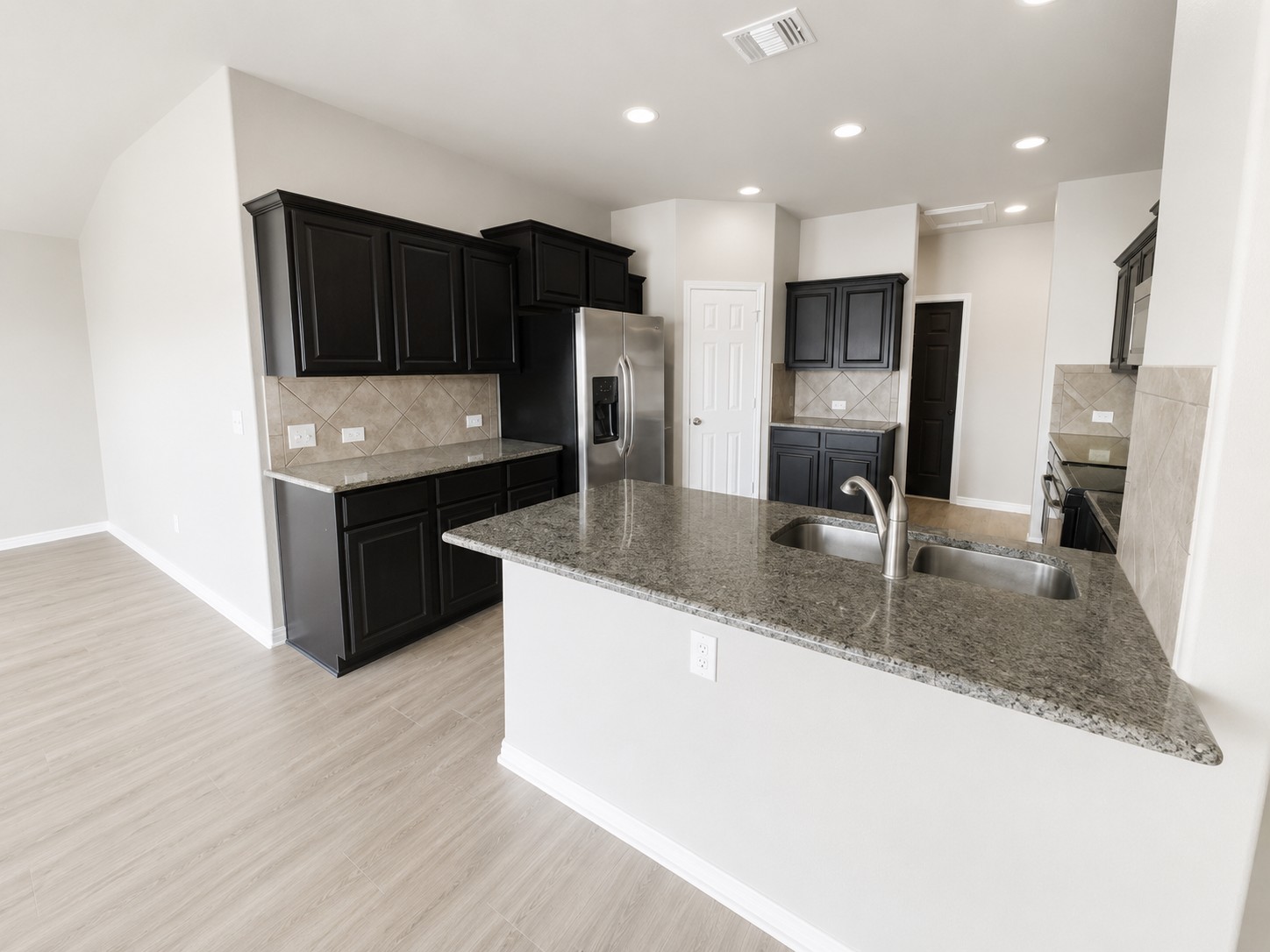 228 Avalanche Avenue Georgetown, TX 78626 - Photo 5 of 16 a kitchen with stainless steel appliances granite countertop a sink stove and refrigerator