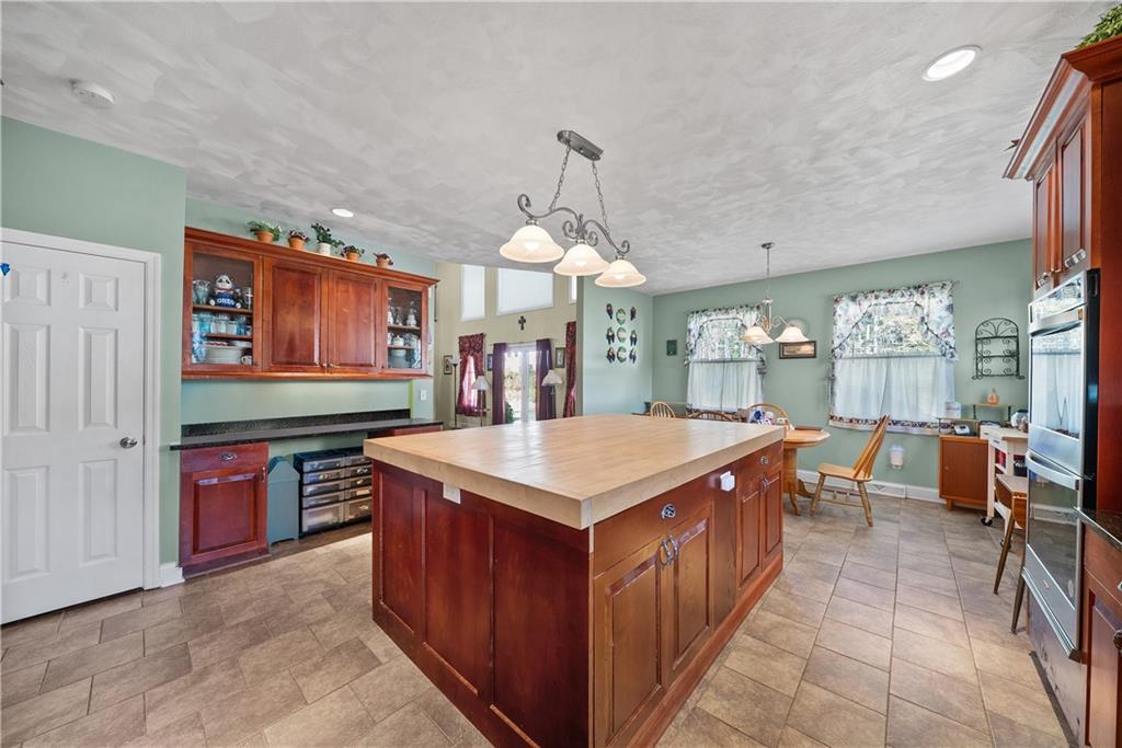 292 Myoma Road Mars, PA 16046 - Photo 26 of 50 a large kitchen with stainless steel appliances a stove a chimney a sink and a dining table
