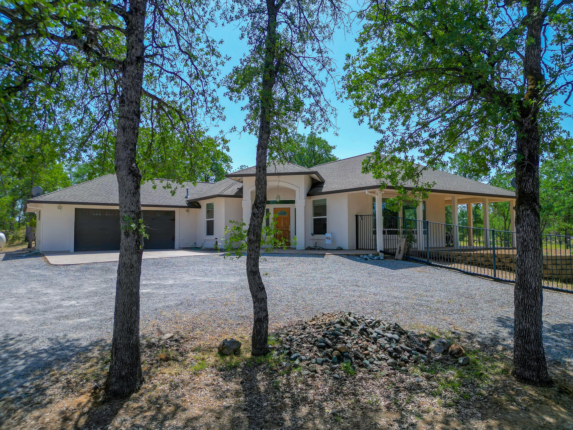 a front view of a house with a garden and trees