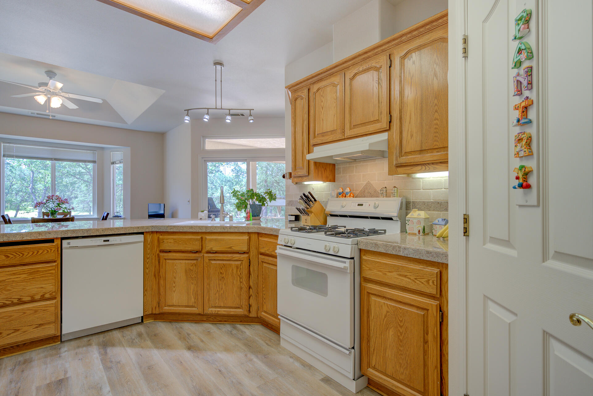 13223 Padani Drive Redding, CA 96003 - Photo 11 of 48 a kitchen with stainless steel appliances granite countertop a sink cabinets and wooden floor