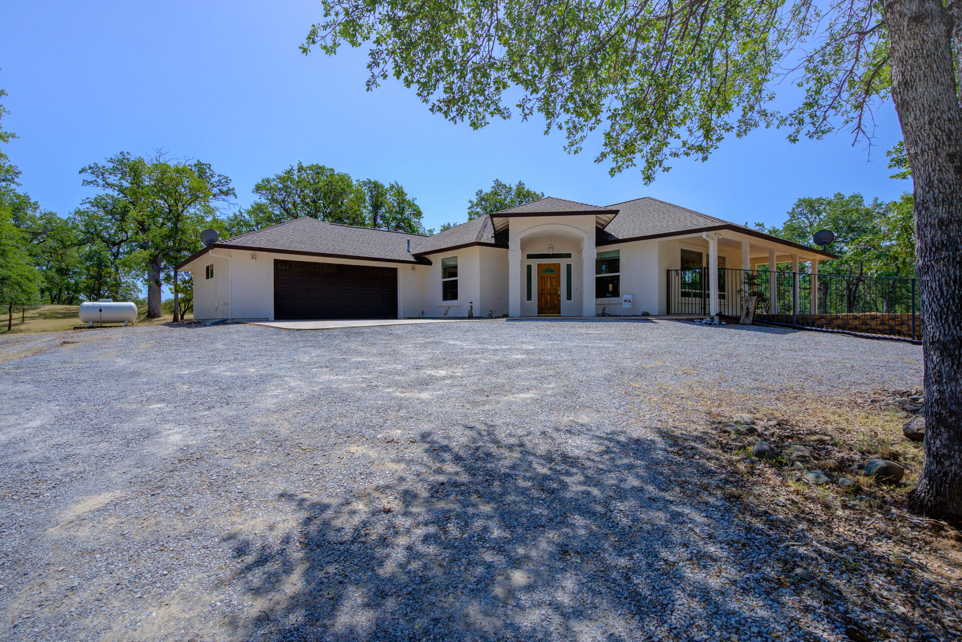 13223 Padani Drive Redding, CA 96003 - Photo 2 of 48 a front view of a house with a garden and trees