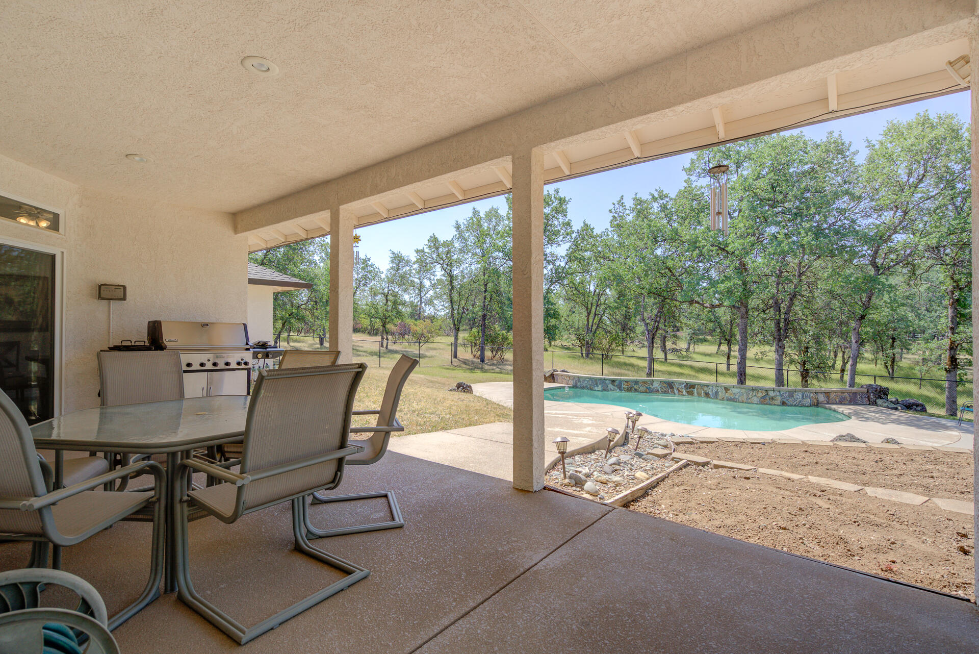 13223 Padani Drive Redding, CA 96003 - Photo 29 of 48 a view of a patio with a table chairs and a backyard