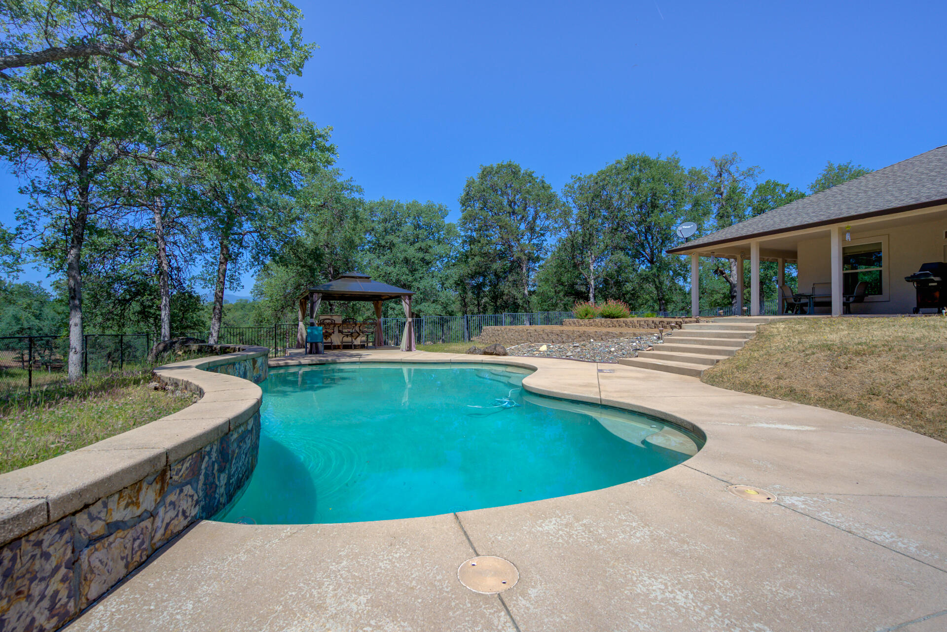 13223 Padani Drive Redding, CA 96003 - Photo 31 of 48 a view of a swimming pool with a patio