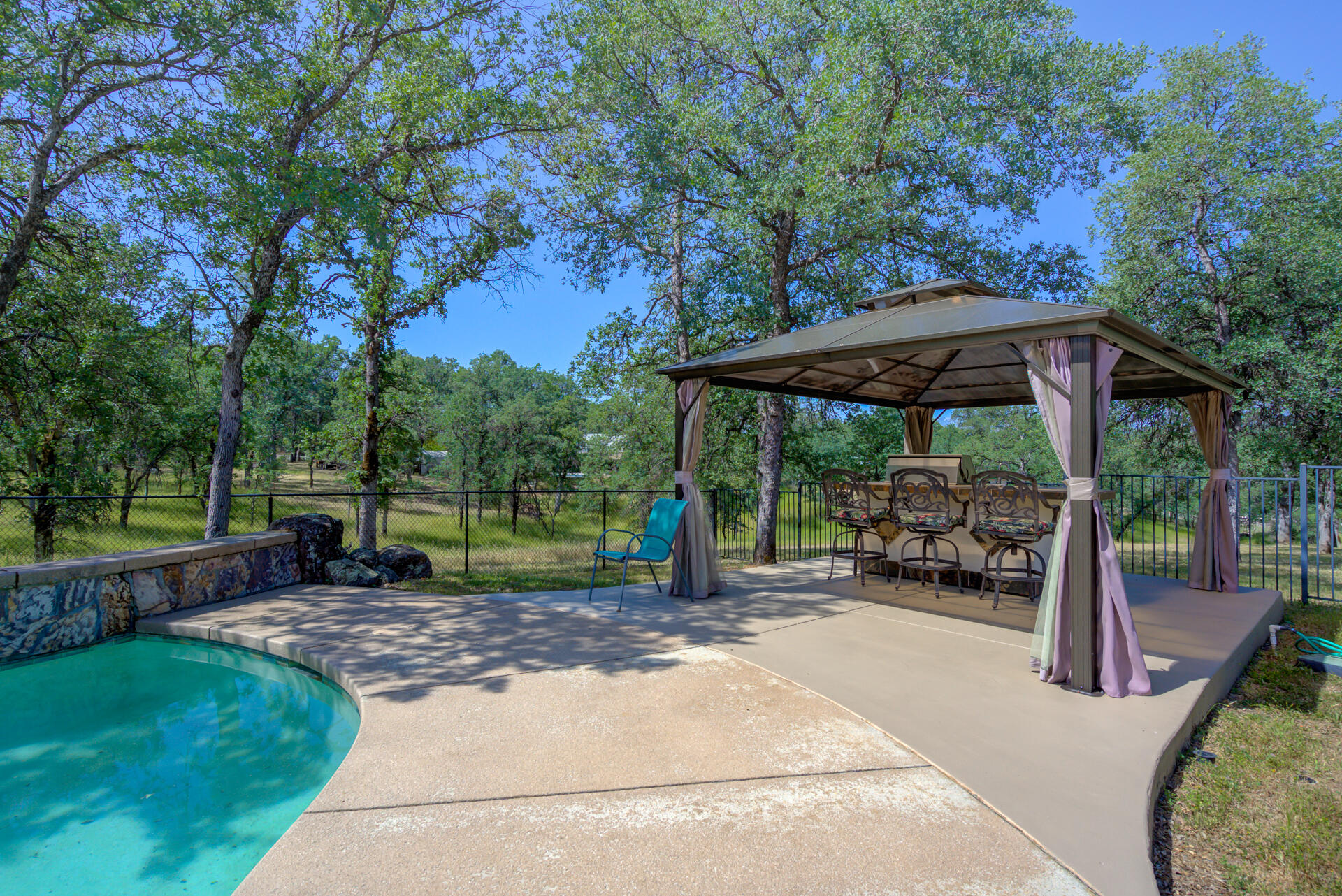 13223 Padani Drive Redding, CA 96003 - Photo 32 of 48 a view of a patio with a table chairs and a umbrella