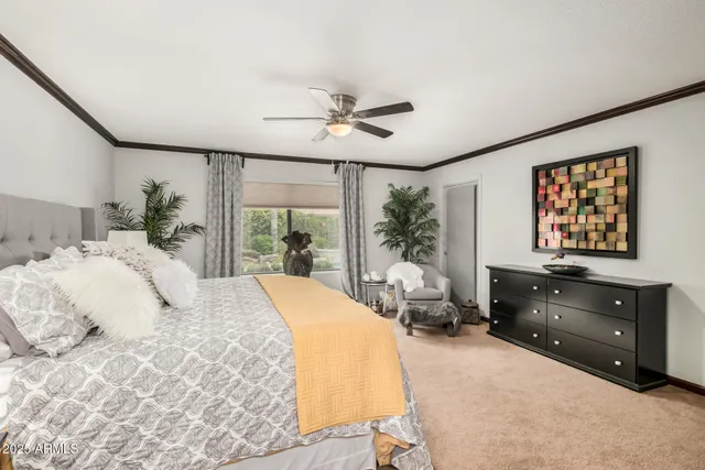 a bedroom with a bed flat screen tv and a large window